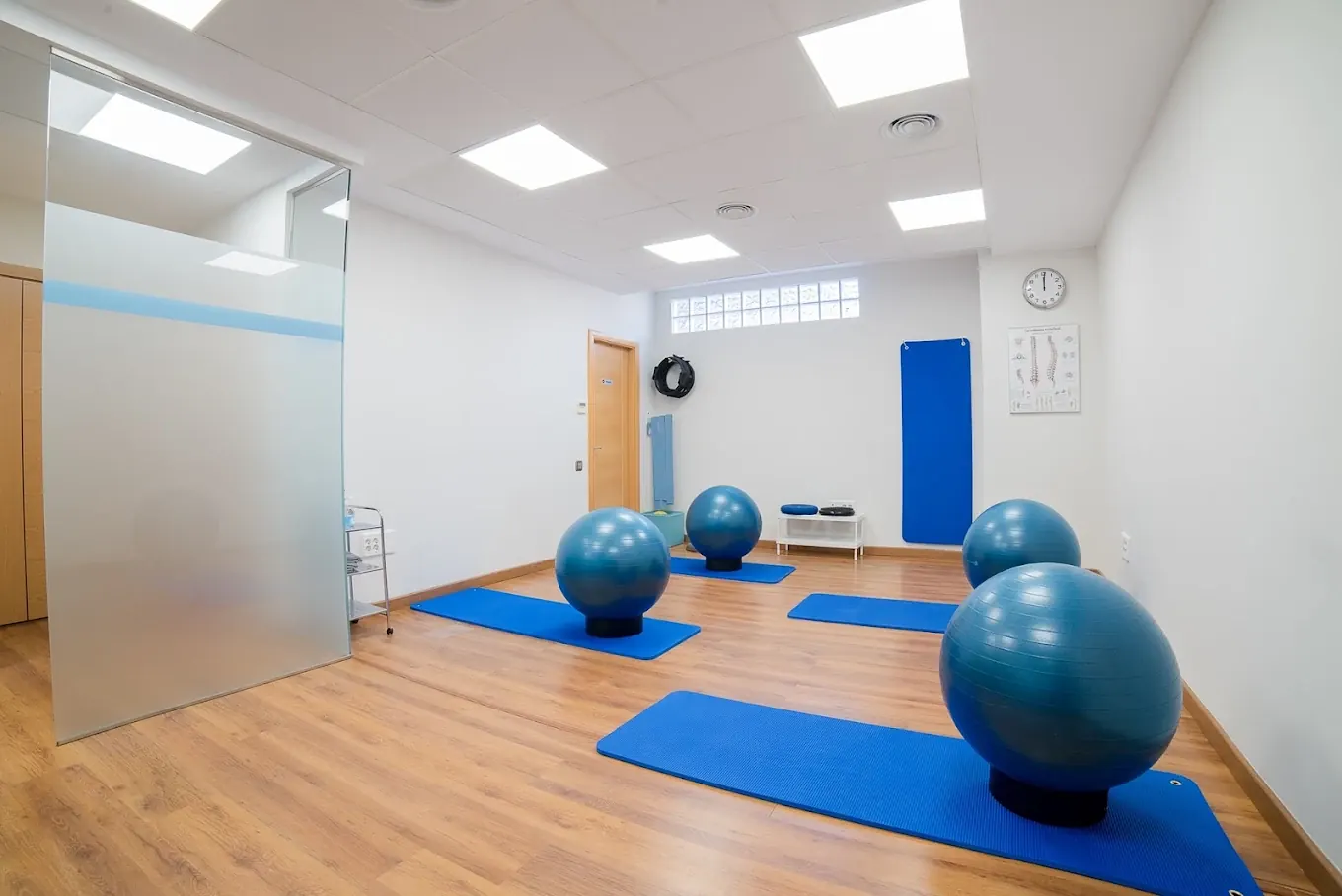 Sala de ejercicio con esterillas y pelotas de pilates azules